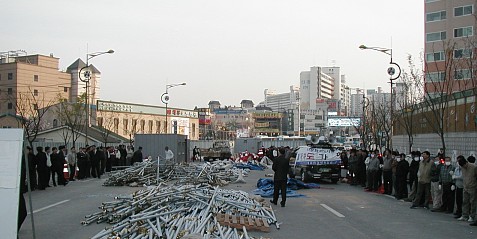 고가차도반대농성주민들이 강제로 끌려나간 뒤 공무원들이 공사현장을 에워싸고 주민들의 접근을 막고 있다. 